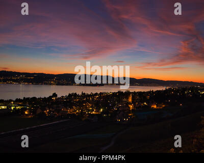 See mit Stadt mit bunten Sonnenuntergang Stockfoto