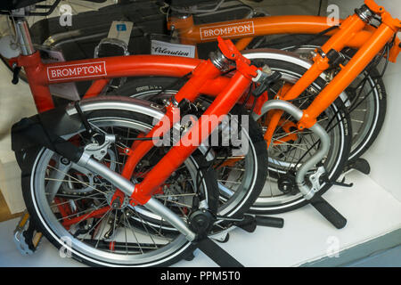 Brompton Falträder in einen kleinen Raum in einem Schaufenster gefaltet. Stockfoto