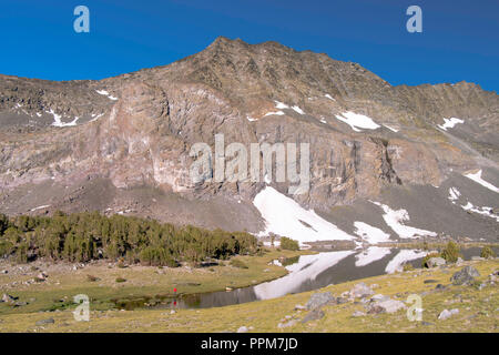 Ein angler nimmt seine Chancen; Sonnenaufgang über Alger Seen mit Asphalt Peak im Hintergrund; Ansel Adams Wilderness, Inyo National Forest, Sierra Beim Stockfoto