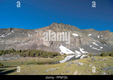 Ein angler nimmt seine Chancen; Sonnenaufgang über Alger Seen mit Asphalt Peak im Hintergrund; Ansel Adams Wilderness, Inyo National Forest, Sierra Beim Stockfoto