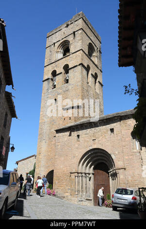 Der Stein romaneque Heilige Maria Kirche (Iglesia de Santa Maria) mit ihrem Glockenturm in Ainsa, einem kleinen ländlichen Dorf in den spanischen Pyrenäen Stockfoto