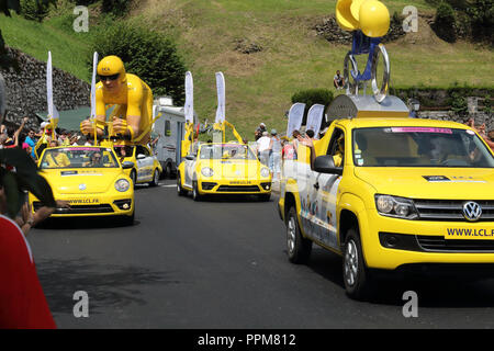 Die gelbe Le Crédit Lyonnais Autos werfen freie Geschenke während der Tour de France 2018 17. Etappe in Soulan, Französisch Pyrennìees, ans Unterstützer. Stockfoto