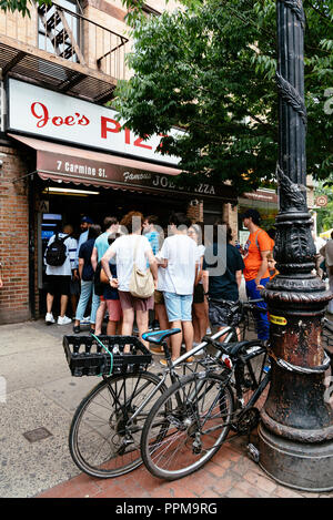 New York City, USA - Juni 22, 2018: eine Reihe von Menschen warten auf die Pizza in der berühmten Joes Pizza Restaurant in Carmine Street in Greenwich Village Stockfoto