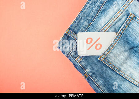 Das Konzept des Verkaufs, der Schwarze Freitag, ein Rabatt mit Blue Jeans auf rotem Hintergrund mit einem Tag in der Tasche Top view Copyspace. Stockfoto