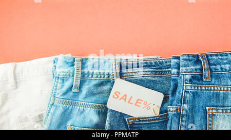 Das Konzept des Verkaufs, der Schwarze Freitag, ein Rabatt mit Blue Jeans auf rotem Hintergrund mit einem Tag in der Tasche Top view Copyspace. Stockfoto