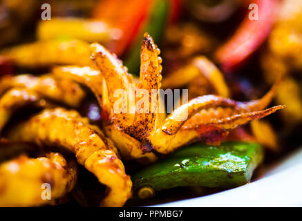 Frittierte Tintenfischringe mit Gemüse auf einem Teller Nahaufnahme Stockfoto