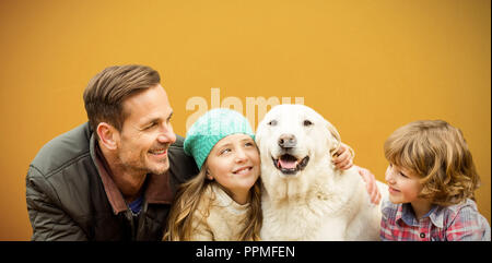 Das zusammengesetzte Bild der glücklichen Familie mit Hund in den Blättern Stockfoto
