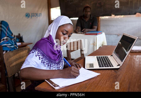 Eingereicht - 27. April 2018, Zentralafrikanische Republik, Bangassou: Oussna Abdraman (17) Aufzeichnen von Notizen während des Studiums in den Computer Lab von Djamaladine Mahamat Salet an eine Siedlung für Intern Vertriebene auf dem Gelände der Bangassou Katholische Mission, Bangassou, Zentralafrikanische Republik, 28. April 2018 eröffnet. Salet, der auch verschoben wird, lehrt Vier zweistündige Sitzungen pro Tag, Montag bis Freitag mit 10 Schülern pro Klasse. Der Preis für den Kurs beträgt 10.000 CFA (ca. USD 19 $) für einen 3-monatigen Kurs. Foto: Baxter / wird Baxter/dpa Stockfoto