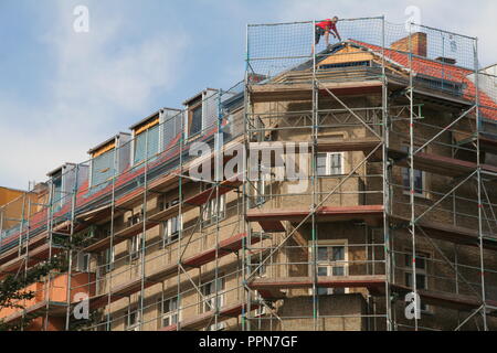 Eingereicht - 21. September 2018, Berlin: Dach Erweiterung und Sanierung eines alten Gebäudes im Bezirk Prenzlauer Berg. Gute Apartments sind rar und in vielen Orten teuer. Laut einer Studie der Hans-Böckler-Stiftung, die sich in der Nähe der Gewerkschaften, 1,9 Millionen erschwingliche Wohnungen sind dringend in den 77 größten deutschen Städten allein benötigt. Die grosse Koalition will mit einer Konstruktion offensive Gegenmaßnahmen zu ergreifen. Jetzt ist ein Vorschlag hinzugefügt: die Zunahme der bereits bestehenden Häusern. Mehr als eine Million neuer Wohnungen verfügen über den Dächern errichtet werden. Foto: Lothar Ferstl/dpa Stockfoto