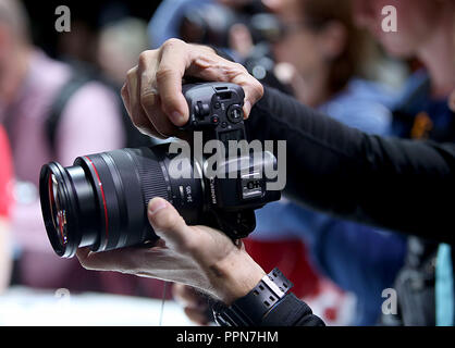 26. September 2018, Nordrhein-Westfalen, Köln: Ein Messebesucher testet eine spiegellosen Digitalkamera (Canon EOS R). Fotografie Photokina, der größten Messe der Welt, wird in Köln stattfinden, bis 29. September 2018. Foto: Oliver Berg/dpa Stockfoto