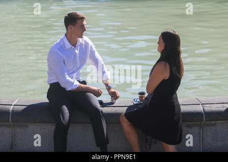 London, Großbritannien. 27 Sep, 2018. Ein paar Genießen der warme Herbst Sonnenschein am Brunnen der Trafalgar Square in der indischen Temperaturen im Sommer in der Hauptstadt der Credit: Amer ghazzal/Alamy leben Nachrichten Stockfoto