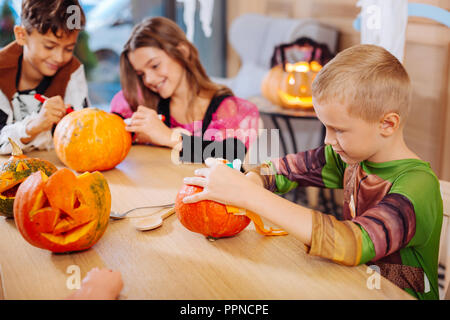 Blonde junge tragen Ninja Turtle Kostüm für Halloween Dekoration Kürbis Stockfoto