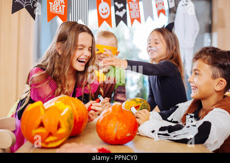 Vier Kinder tragen Halloween Kostüme laut lachend während der Party Stockfoto