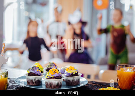 In der Nähe von blauen Platte mit schönen hellen Halloween cupcakes stehend auf dem Tisch Stockfoto