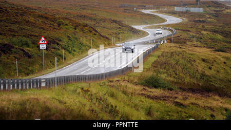 Autos fahren auf der A835 in der Nähe von ULLAPOOL SCHOTTLAND RE BIEGUNGEN IN DIE HIGHLANDS FAHREN an entfernten Standorten nassen Straßen schottischen UK Stockfoto