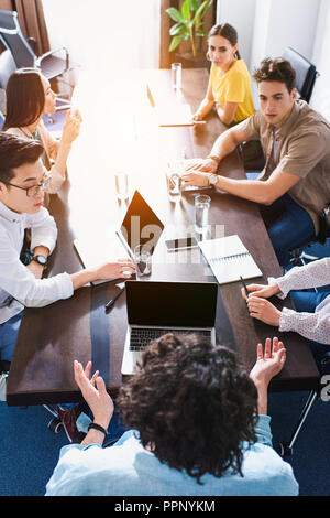 Hohe Betrachtungswinkel und der multikulturellen Business Partner in Sitzung am Tisch mit Laptops in modernen Büro Stockfoto