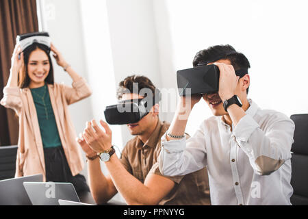 Zwei lächelnde Geschäftsleute mit Virtual reality Headsets im modernen Büro Stockfoto