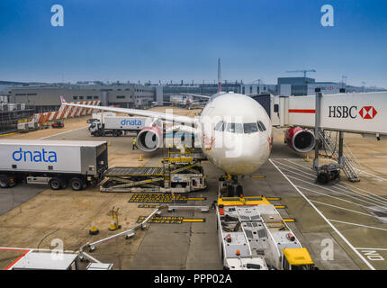 LONDON HEATHROW - JUNI 2018: Weitwinkelaufnahme der Luftfracht in den Laderaum ein. Virgin Atlantic Airbus A330 am Flughafen Heathrow geladen wird. Stockfoto