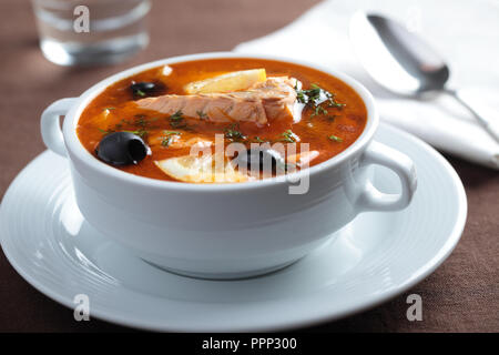 Solyanka, russische Suppe mit Lachs, Oliven und Zitronen Stockfoto