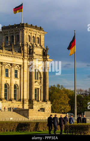 Berlin, Deutschland, 10.04.2017, formell gekleidete Menschen an das deutsche Parlament zu gehen. Wehende Fahnen auf blauen Himmel Hintergrund Stockfoto