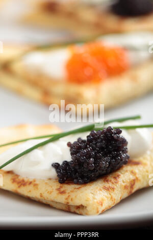 Crepes mit roter und schwarzer Kaviar auf einer Platte Stockfoto