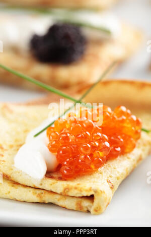 Crepes mit roter und schwarzer Kaviar auf einer Platte Stockfoto