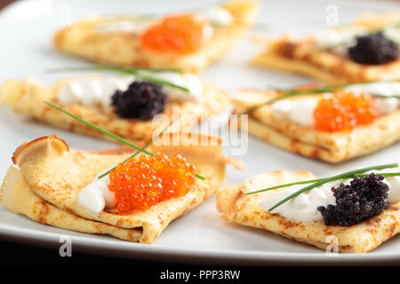 Crepes mit roter und schwarzer Kaviar auf einer Platte Stockfoto