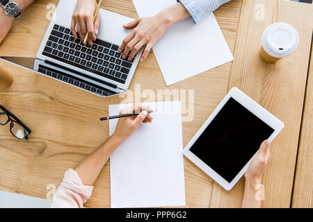 Zugeschnittenes Bild von Kolleginnen und Kollegen beim Start Projekt im Büro mit Tablet-PCS und Notebooks Stockfoto