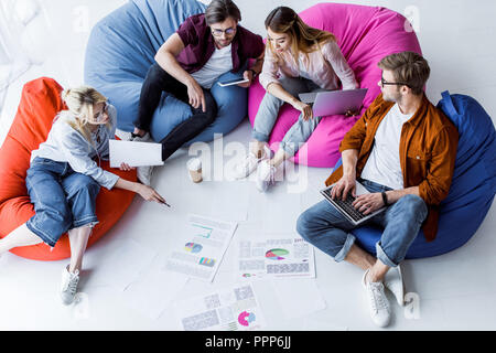 Hohe Betrachtungswinkel und der multikulturellen Kollegen diskutieren Startprojekt im Büro Stockfoto