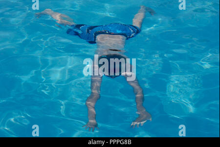 Zehn Jahr auf junge Schwimmen im Pool. Stockfoto