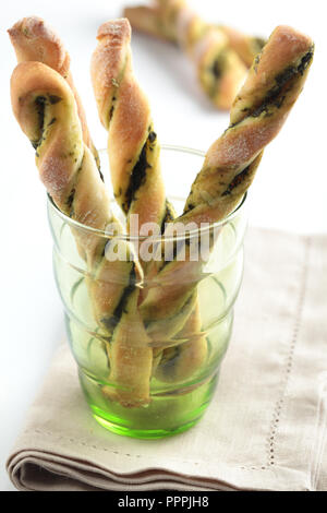 Gebackene Grissini mit Pesto in einem grünen Glas Stockfoto