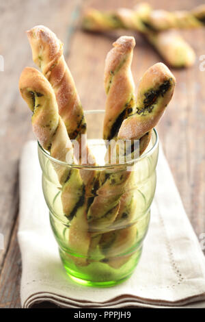 Gebackene Grissini mit Pesto in einem grünen Glas Stockfoto