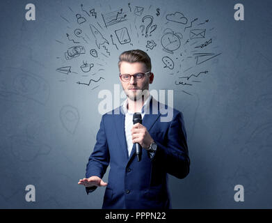 Geschäftsmann sprechen in das Mikrofon mit gemischten Doodles über seinem Kopf Stockfoto