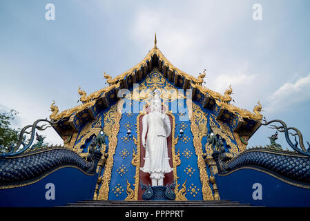 Von unten zeigen weißer Buddha Statue im Design von Wat Rong Suea Zehn (auch als Blue Tempel bekannt) mit goldenen Ornamenten, Thailand Stockfoto