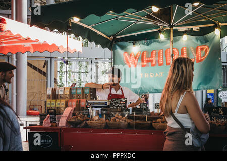 London, Großbritannien - 17 September, 2018: Die Menschen kaufen artisan Fudge aus einem Marktstand in Borough Markt, eines der größten und ältesten Märkte in Lond Stockfoto