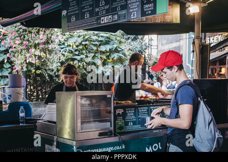 London, Großbritannien - 17 September, 2018: Die Menschen essen Bestellen von Boston Würstelstand in Borough Markt, eines der größten und ältesten Märkte in London. Stockfoto