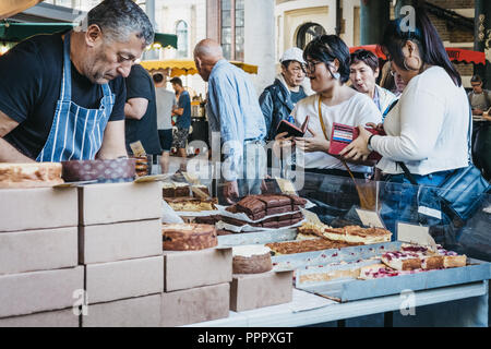 London, Großbritannien - 17 September, 2018: Die Menschen kaufen frische artisan Kuchen und Gebäck von einem Marktstand in Borough Markt, eines der größten und ältesten f Stockfoto