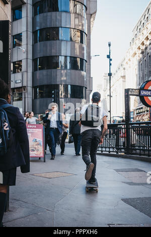 London, Großbritannien - 17 September, 2018: Junger Mann auf einem Skateboard reiten auf einem Gehsteig in der City of London, London, UK, berühmten Londoner Financial District. Stockfoto