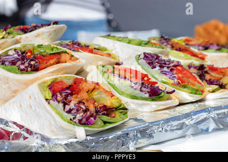 Wraps mit Fleisch und Gemüse, Kohl, Paprika, Tomaten und Kopfsalat. Metall Tablett mit Wraps, angezeigt Angebot für Besucher des Asiatischen Street Food m Stockfoto