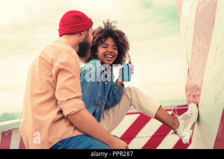 Begeistert junge Mädchen schließen ihre Augen beim Hören von Ihrem Freund Stockfoto