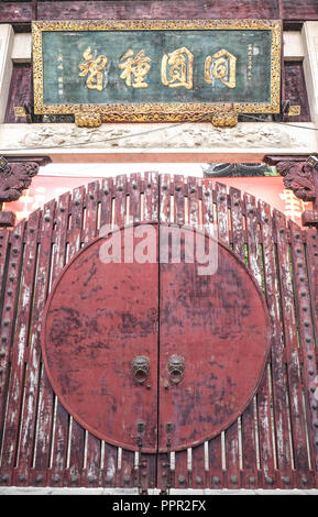 Shanghai, 18.06.22; 2018. Die rote Farbe auf die Tür knackt und schälen. Holz- chinesischen Carven auf alte Holztür. Stockfoto