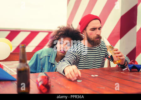 Verschlafene mann Bier trinken nach dem lästigen Partei Stockfoto
