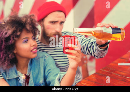 Junge Frau mit der Glas- und ihrem Freund Bier Stockfoto