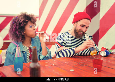 Positive Paar am Tisch sitzen und ihre Partei Stockfoto