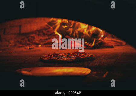 Professionelle Pizzaofen. Ein gutes Feuer brennt im Ofen. Pizza in den Ofen. Stockfoto