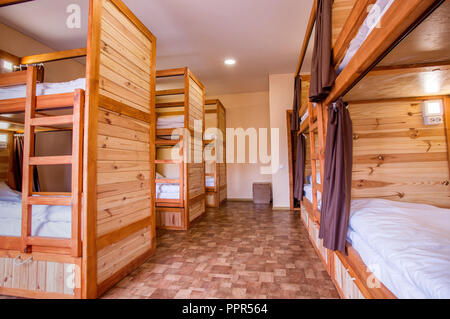 Persönliche Beleuchtung über jedem Bett. Etagenbetten Betten aus Holz in der Herberge. 5 Etagenbetten in einem Hostel Zimmer Stockfoto