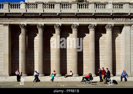 Leute sitzen auf der südlichen Fassade der Bank von England, London, England, UK. Stockfoto