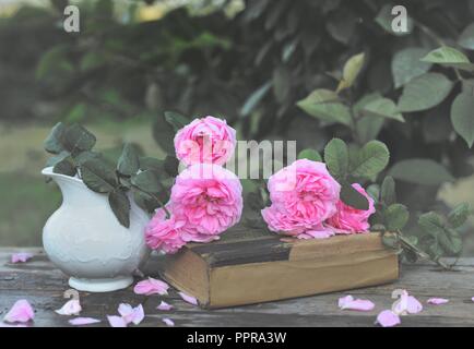 Noch immer leben mit einem Blumenstrauß aus Rosen und ein Buch Stockfoto