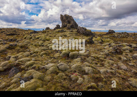 Ein bewölkter Himmel und die alten Lavafeld, mit Moos in der Nähe von Vik, Island, von der berühmten Ringstraße gesehen, die gut von Touristen gereist ist, bedeckt. Stockfoto