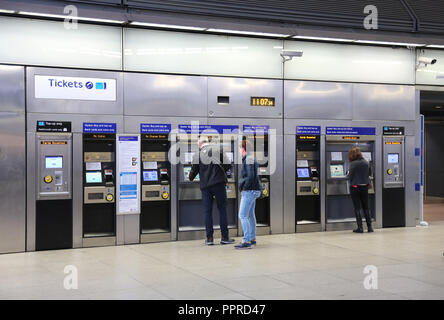Eine Bank von Self-service-Automaten in der Londoner Canary Wharf U-Bahnstation. Zeigt den Kunden über Touch-screens und Oyster Card Reader. Stockfoto
